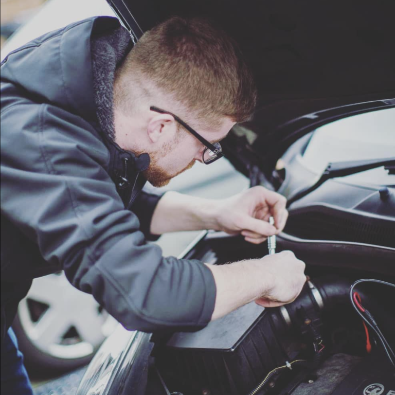 Automotive technician under the bonnet of a car